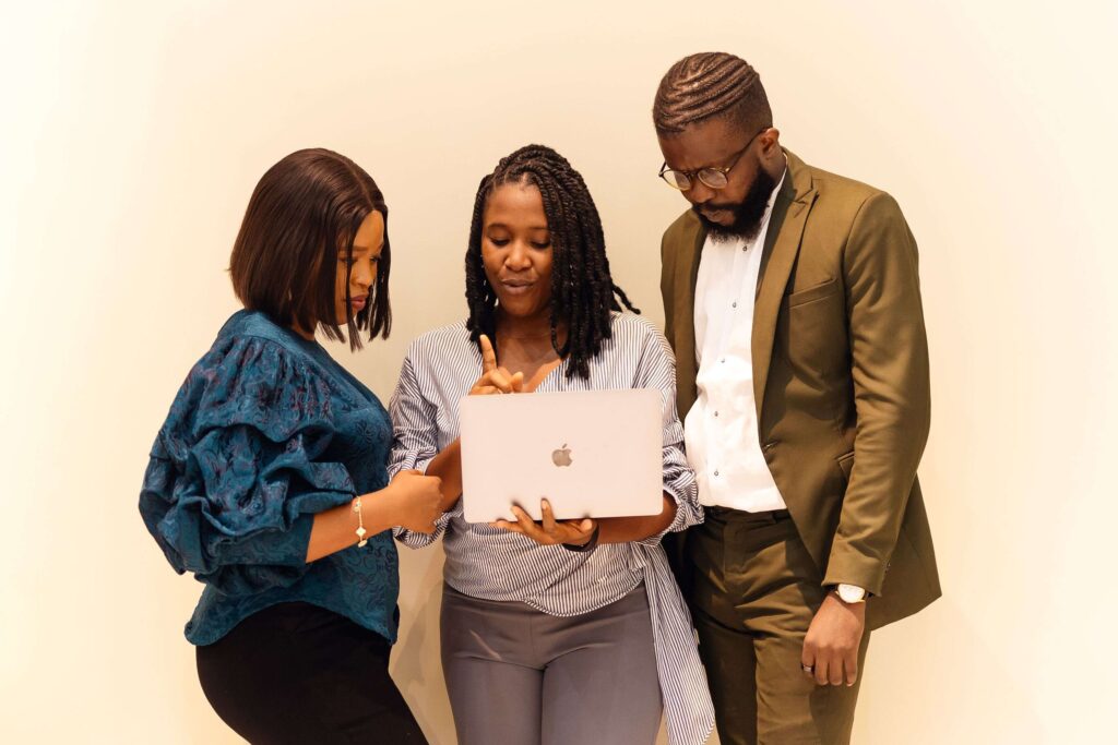 Business professionals collaborate over a laptop during a meeting in an office in Lagos